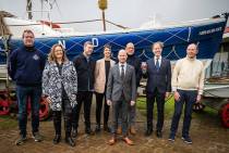 V.l.n.r. KNRM Lifeguard Hein Willem Kootstra, staatssecretaris Aukje de Vries, ontwerpers van de munt Hendrik-Jan Grievink en Coralie Vogelaar, KNM-muntmeester Bert van Ravenswaaij, chef-kok Herman den Blijker, KNRM-directeur Jacob Tas en nazaat van Abraham Fock; Bart Fock. Fotograaf Jantina Scheltema. 