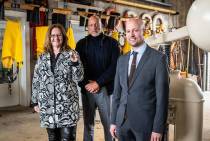 Staatssecretaris Aukje de Vries, chef-kok Herman den Blijker en KNM-muntmeester Bert van Ravenswaaij met de geslagen herdenkingsmunt voor het 200-jarig bestaan van de KNRM in het Abraham Fock-museum op Ameland. Fotograaf Jantina Scheltema. 