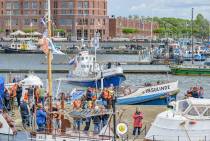 Flinke drukte in de Bataviahaven, reddingboten varen af en aan