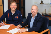 John van Doorn (r) en KNRM-directeur Jacob Tas tekenen de overeenkomst voor de donatie van een Nh1816-2 op het KNRM-kantoor in IJmuiden. Foto Suzanne Kuijer/ KNRM