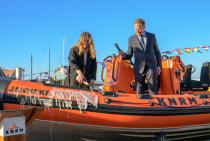 Jacob Tas, directeur van de KNRM kijkt toe hoe de kleindochter van schenker Arie Hoek, Willemijn van den Dool, de nieuwe reddingboot 'Janneke - Patricia' doopt. Fotograaf Roel Ovinge. 