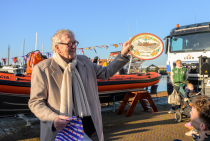 Schenkster Arie Hoek ontvangt een cadeau, Hindelooper schilderkunst, van het reddingstation. Fotograaf Roel Ovinge. 