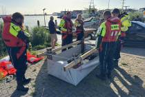 Deelnemers bouwen een vlot waarmee een parcour moet worden afgelegd in het water