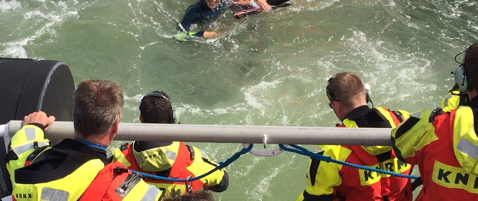 Kitesurfer wordt uit zee gehaald
