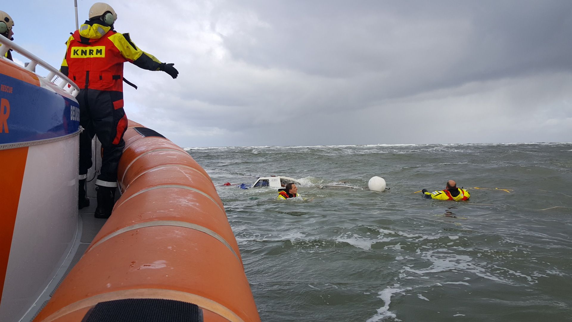 Opstappers gaan te water om in het water het jacht sleepklaar te maken.