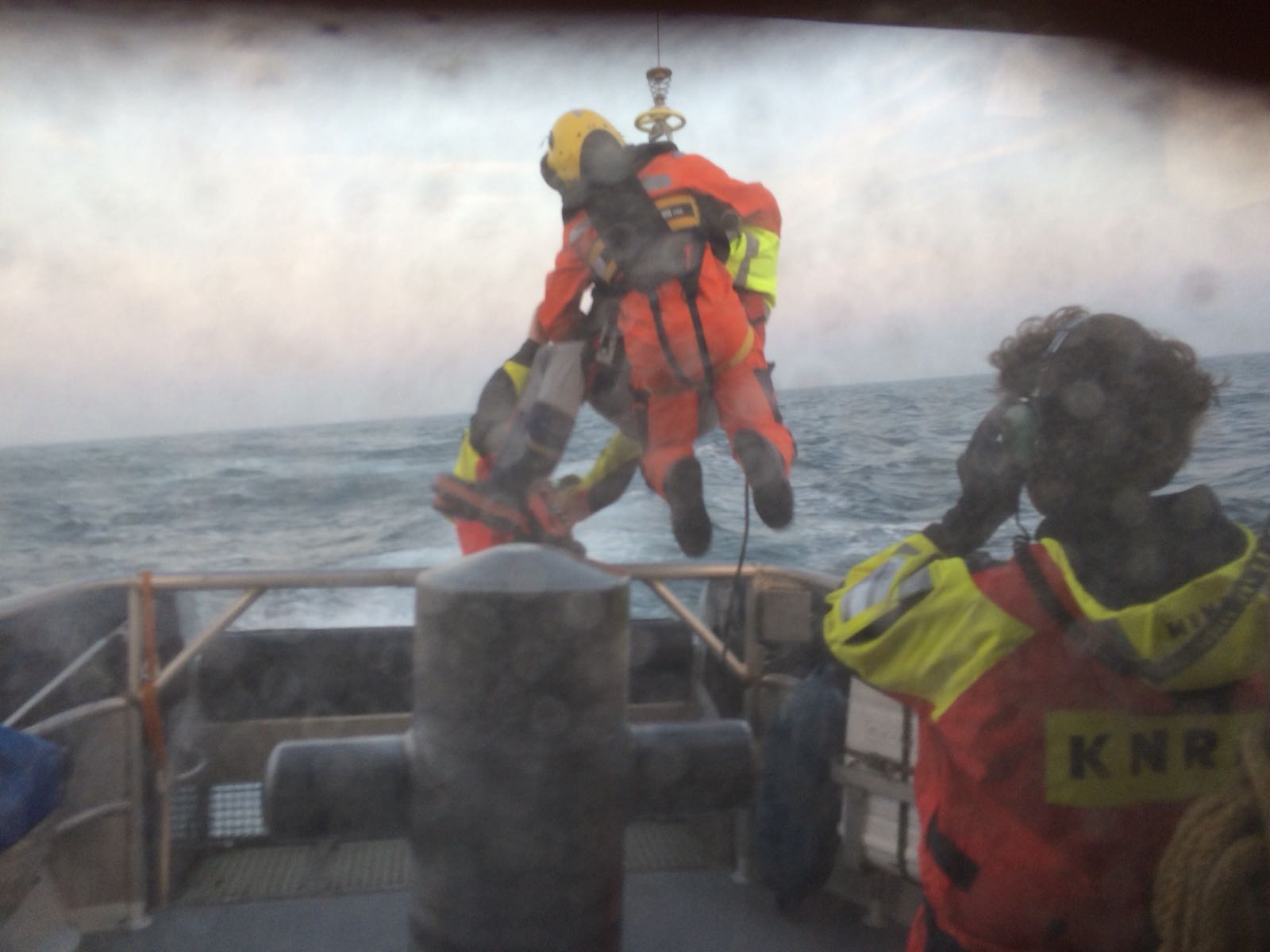 De drenkeling wordt door de heli opgehaald