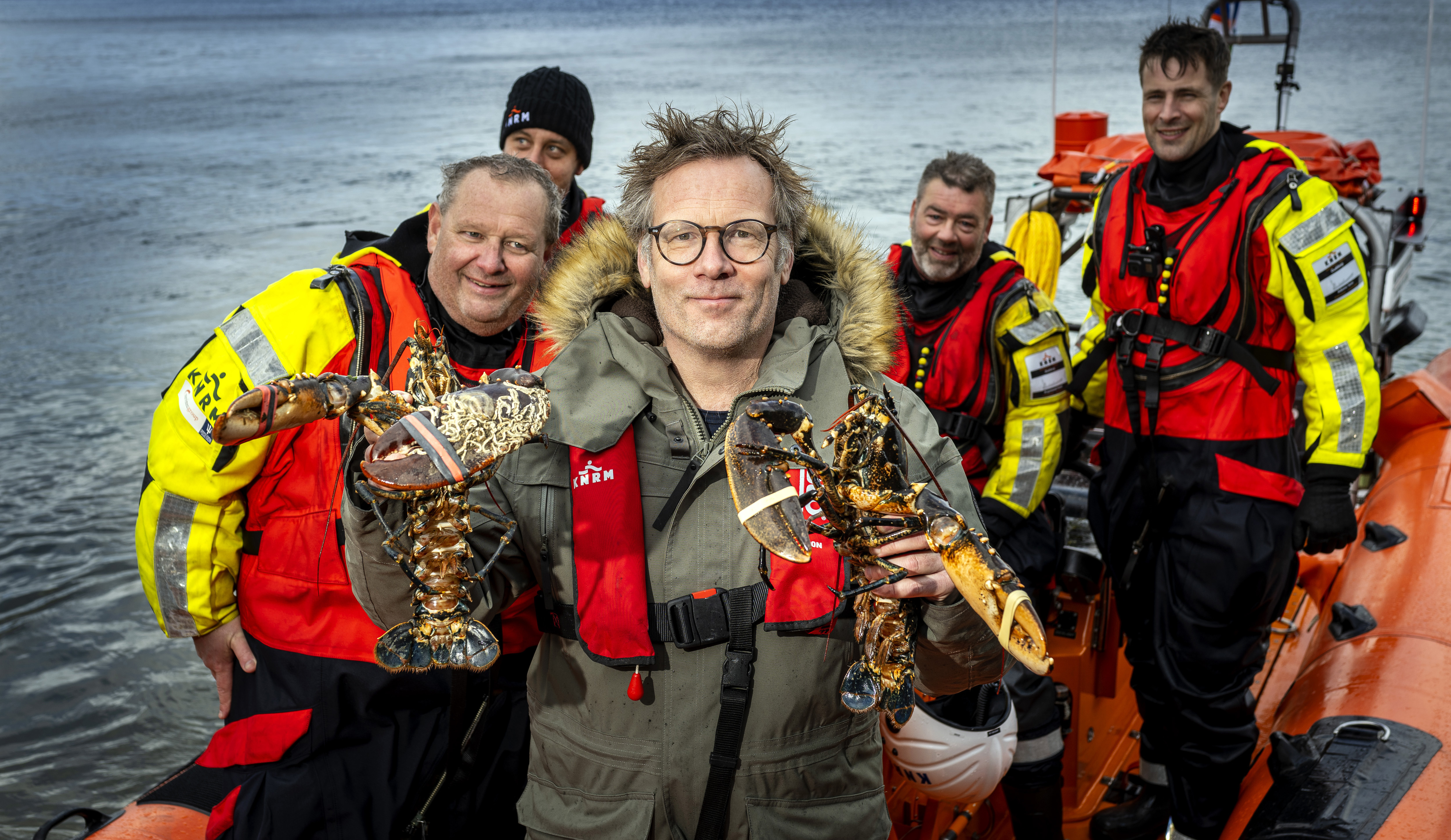 Patrick Lodiers met de eerste twee Oosterscheldekreeften aan boord van KNRM.